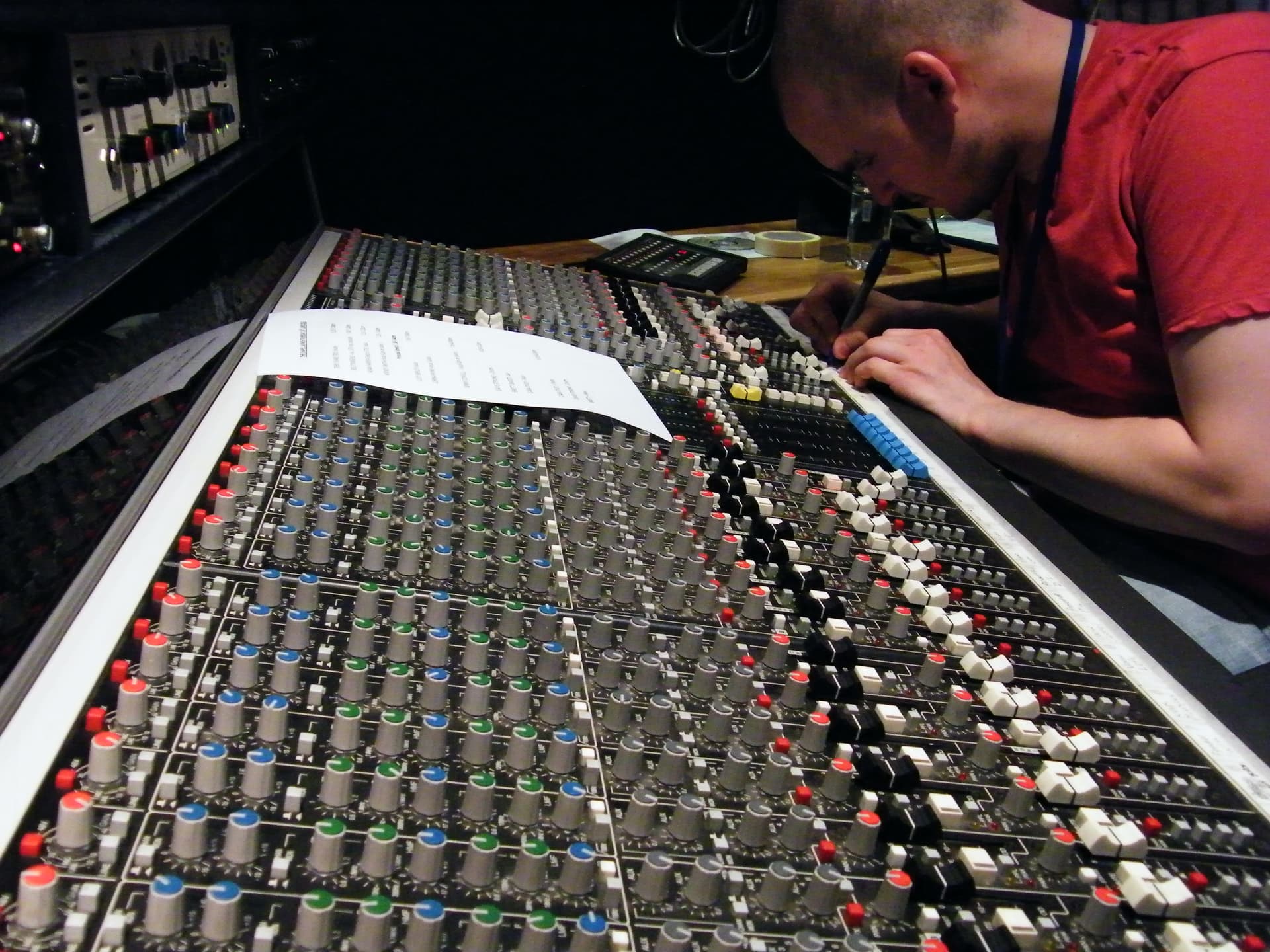 James at a professional mixing console, hands on the faders
