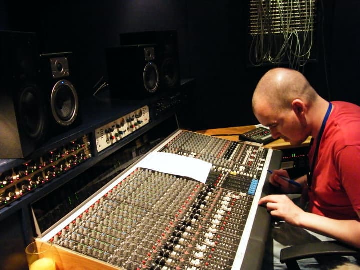James working at a large studio mixing desk