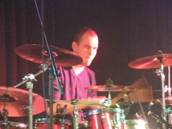 James playing drums on stage, close-up